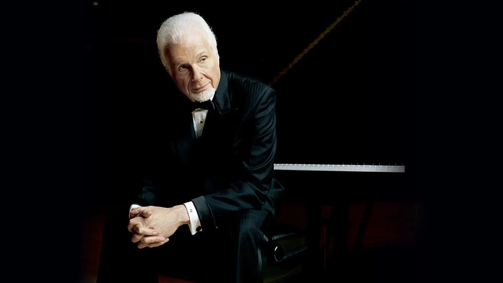 Peter Nero sitting on a piano bench.